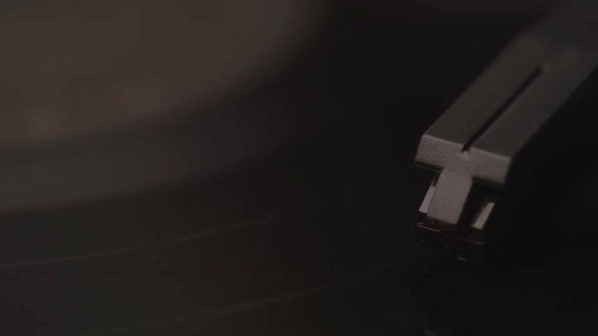 A turntable shows a record spinning as the needle glides along its grooves playing a song