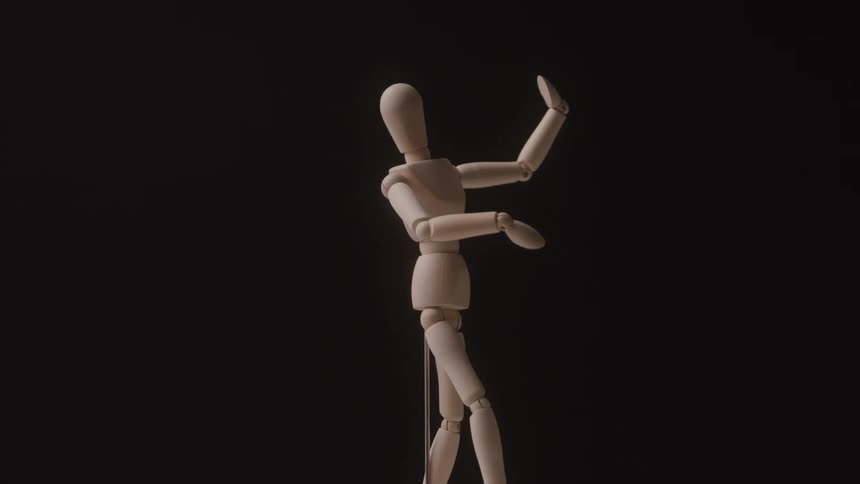 Wooden articulated mannequin posing with one arm raised