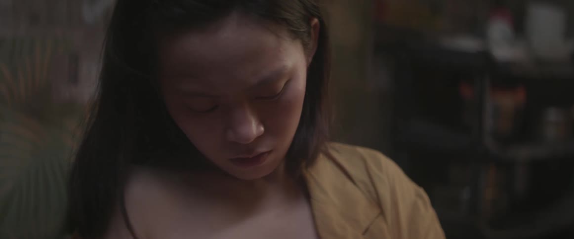 An asian woman looks nervously downward