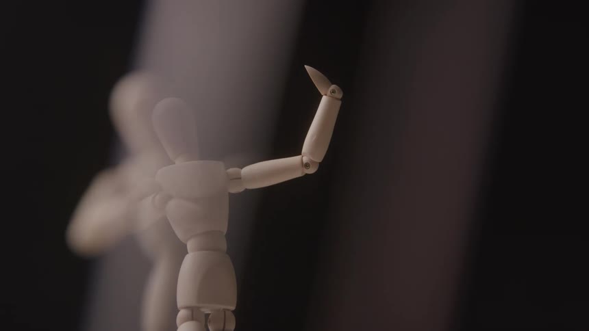 A close view shows a wooden art mannequin with arms raised