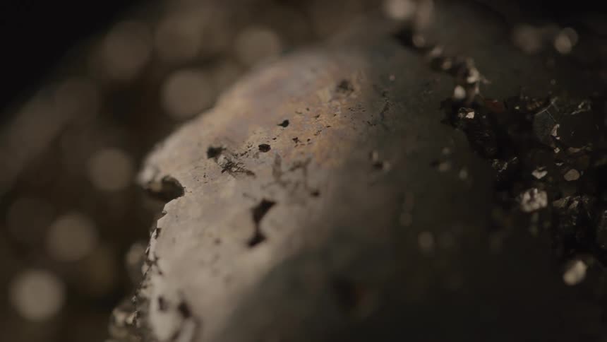 A raw uncut crystal or metallic rock set within a rocky environment