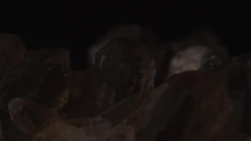 Closeup of smoky quartz crystals against a dark background