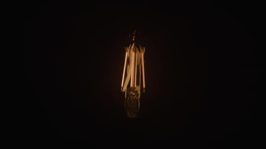 A figure of a woman has lights flashing on her in the dark