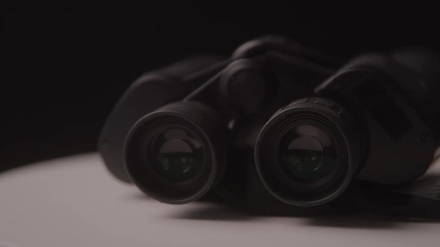 Black binoculars resting on a light surface