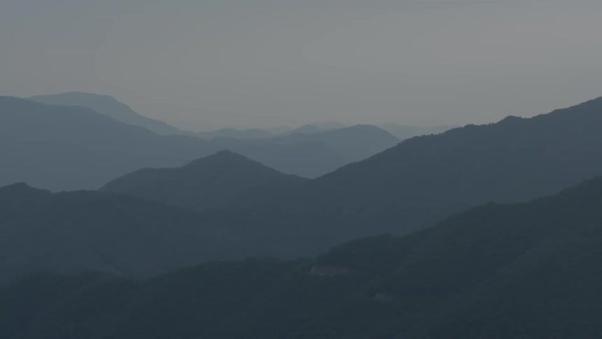 A view of a lot of mountains that are covered with a fog
