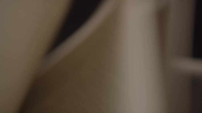 The video shows a book with its pages flipping rapidly in a closeup shot the pages are a beige color and the text on them is out of focus