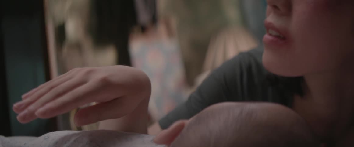 A close up view of a woman's hand and a baby's head