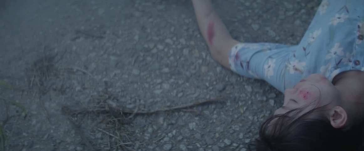 A woman is lying on the pavement