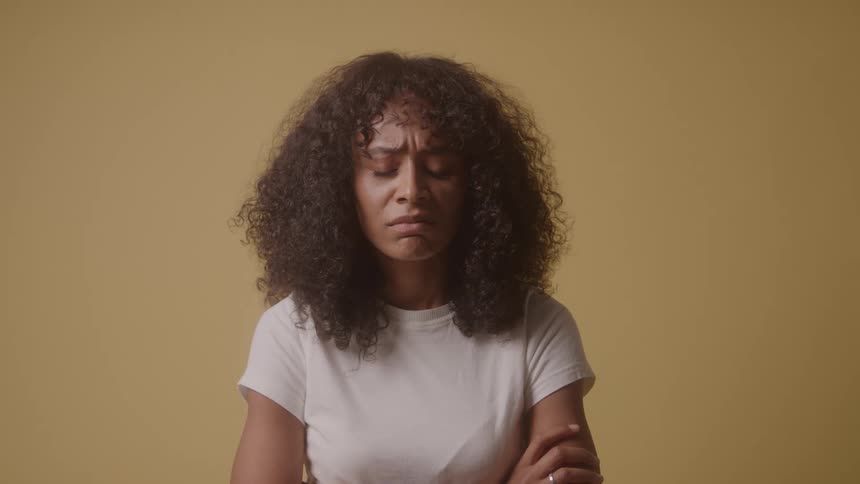 A woman with her arms crossed in front of her snaps her fingers in disappointment