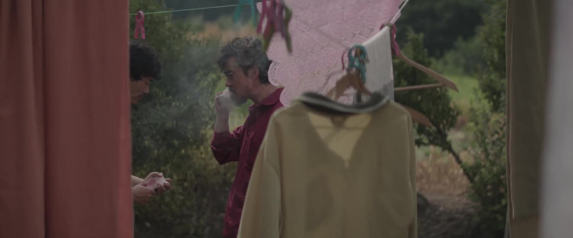 People are handing off money and smoking in a yard