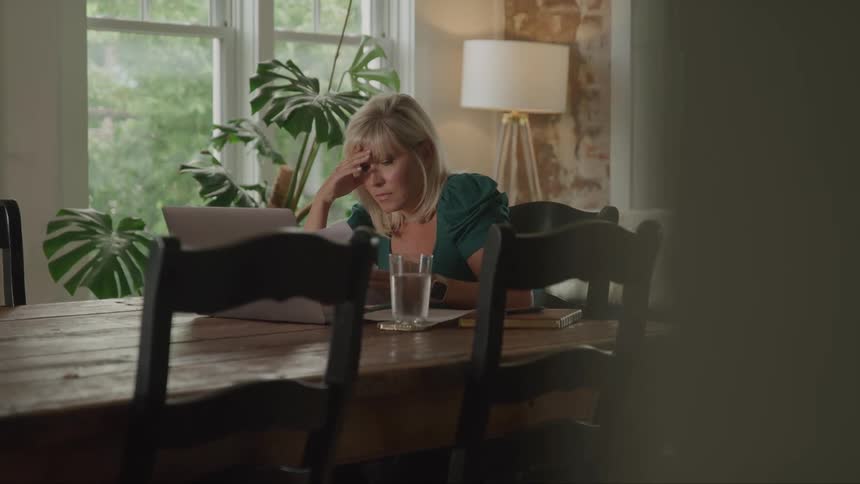 Woman sitting at a table and reading a document