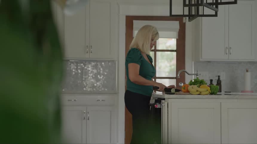 Woman cutting vegetables in a bright modern kitchen