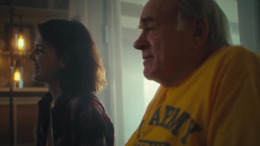 Woman and man smiling while looking at something offframe