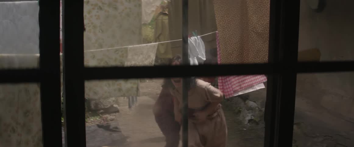 A woman trying to run away from a man in the yard as they fight