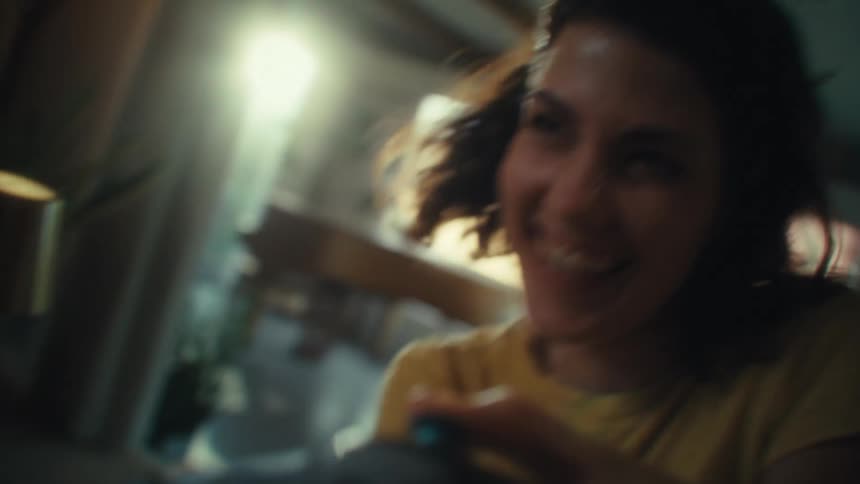 Woman with an intense look of concentration while playing video games with a controller in her hands