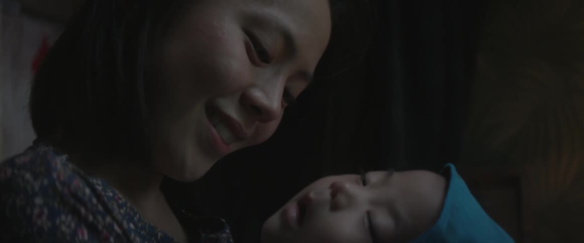 An asian woman sings and smiles