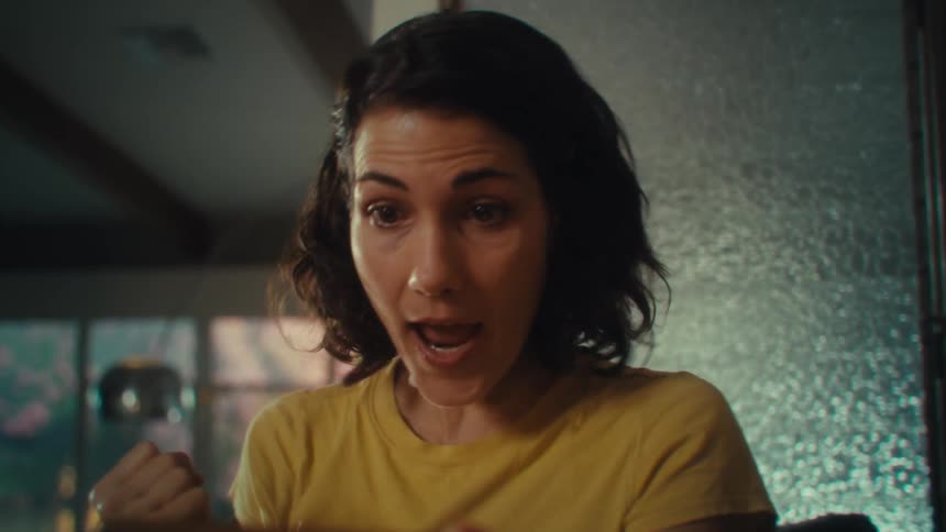 Woman with an excited expression while holding a cellphone and raising her arm