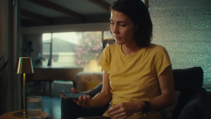 Woman sitting and using her cellphone with her fingertips