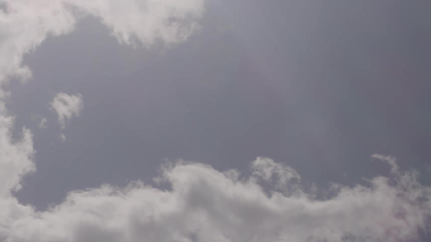 Fluffy clouds pass by overhead