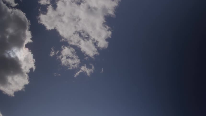 Fluffy clouds pass by overhead