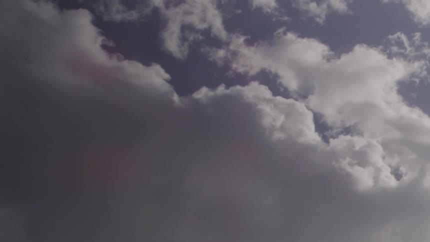 Fluffy clouds pass by overhead