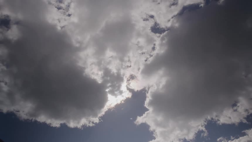 Large white clouds rolling across the sun