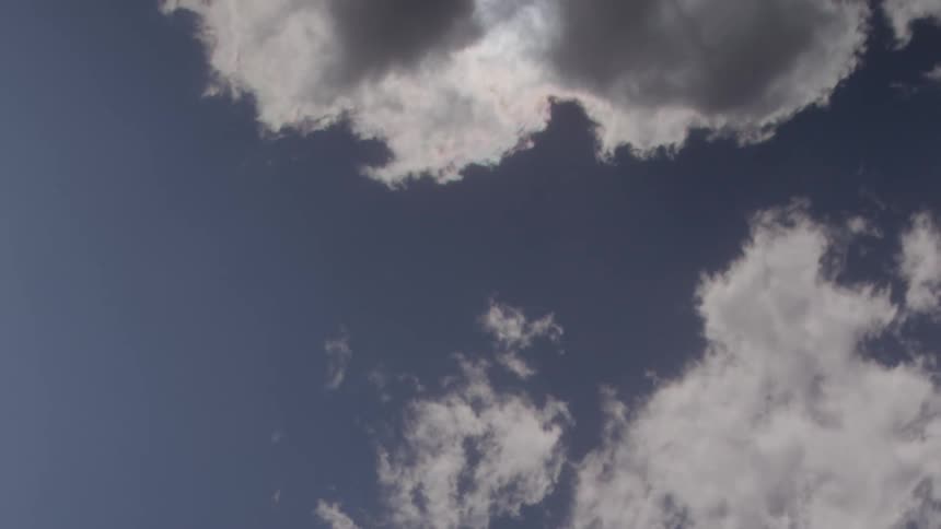 Fluffy clouds pass by overhead