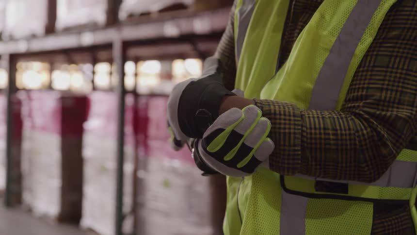 A worker puts on work gloves