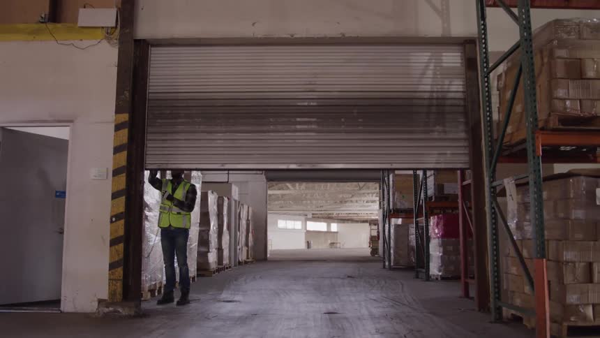 A worker closes a metal gate