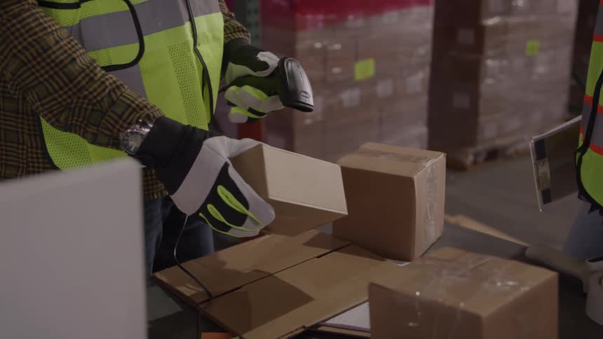 Worker scanning barcode on cardboard box