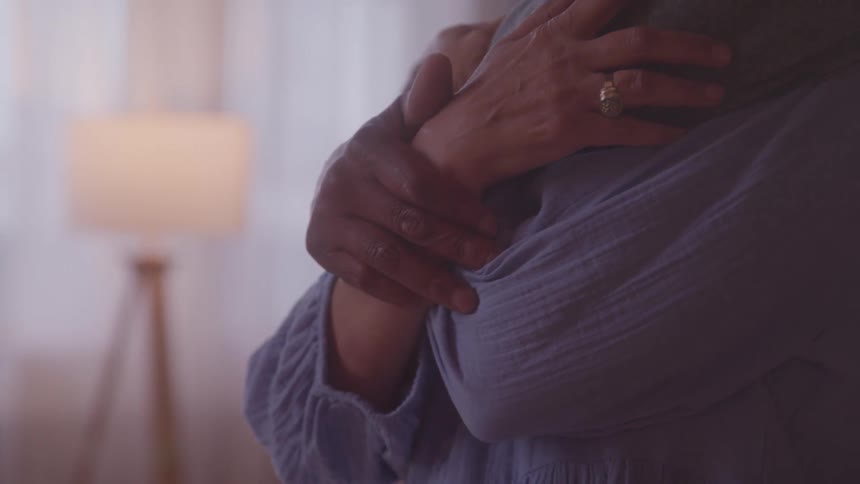 Two people hugging with their hands intertwined
