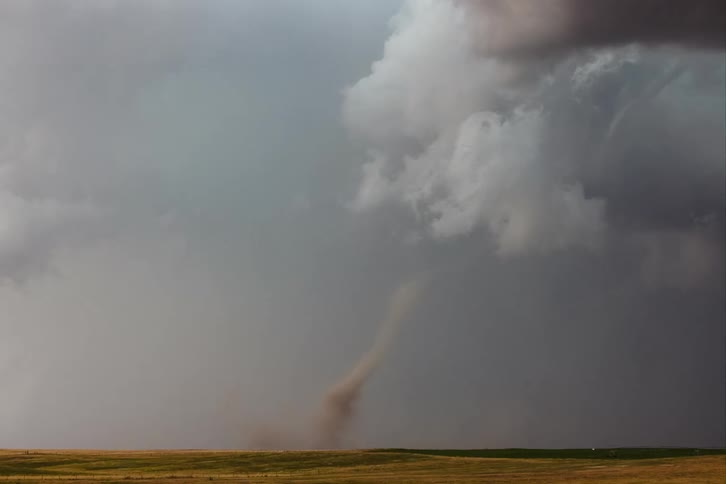Dark storm clouds loom over open plains