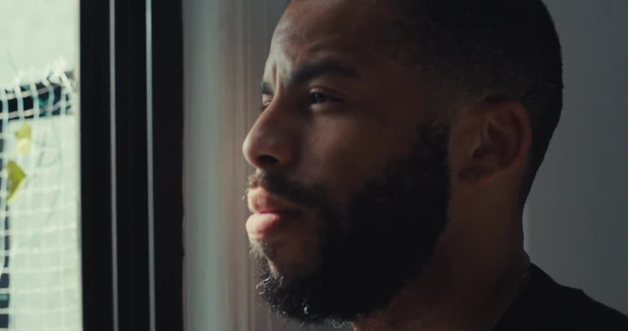 Man sits by window lost in thought