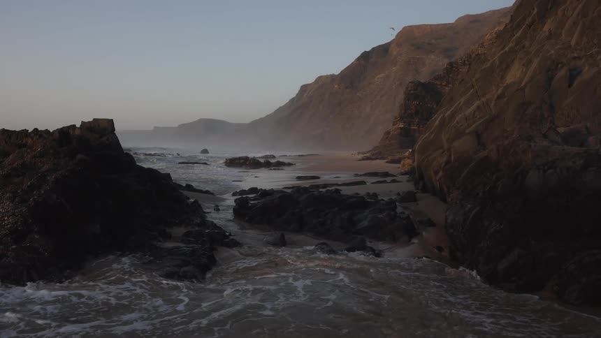 Sea between rock formations with cliffs in the background