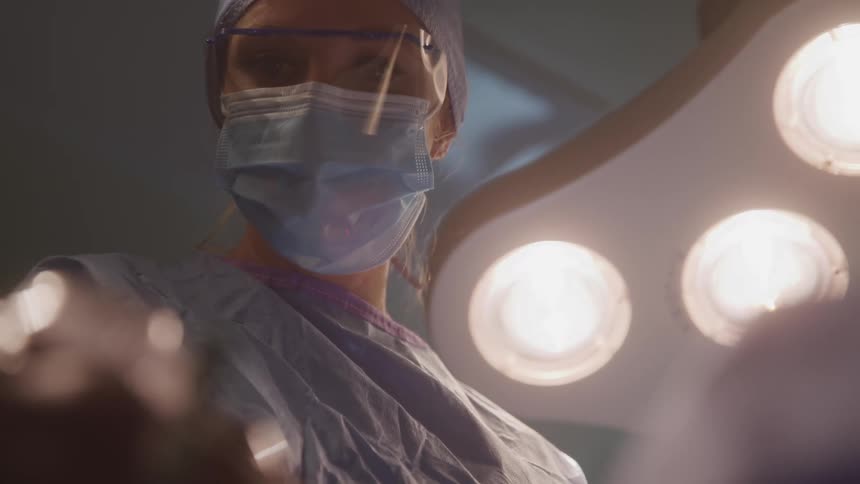 Surgeon wearing a mask and protective glasses in an operating room