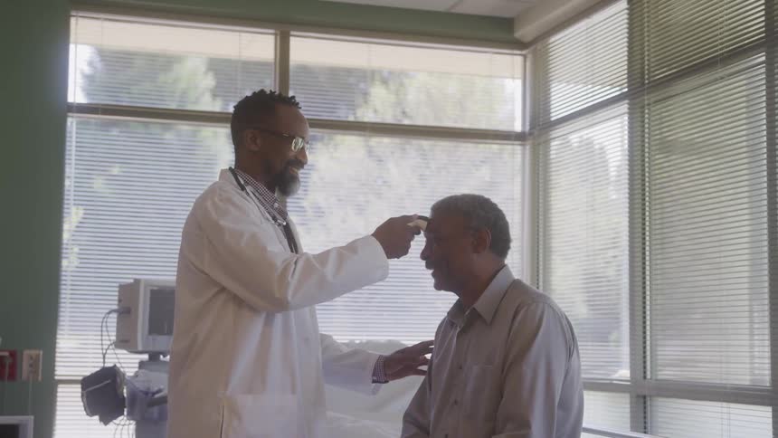 Doctor checking a patients temperature with a forehead thermometer