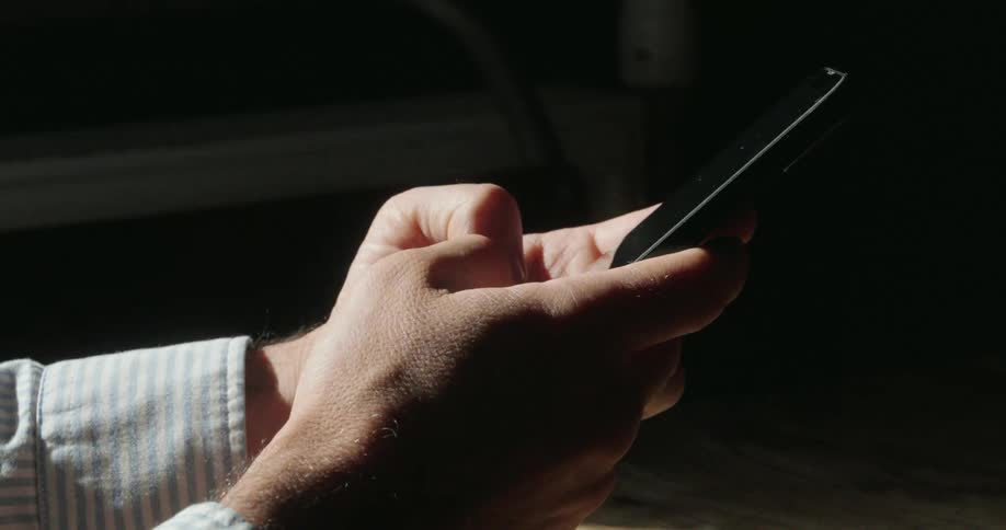 A man is typing on his cell phone