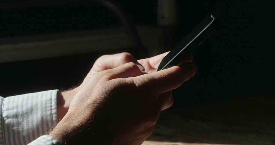 The man is texting on his phone at home