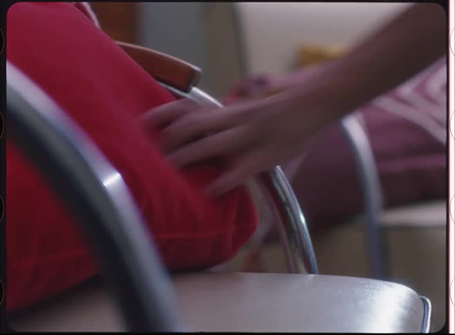 A person picks the pillow up from the chair