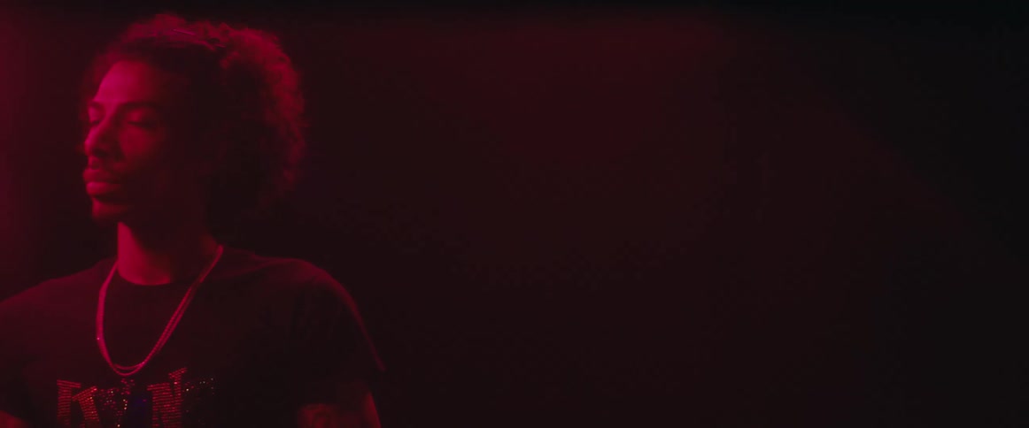 Man illuminated by red light in a dark environment