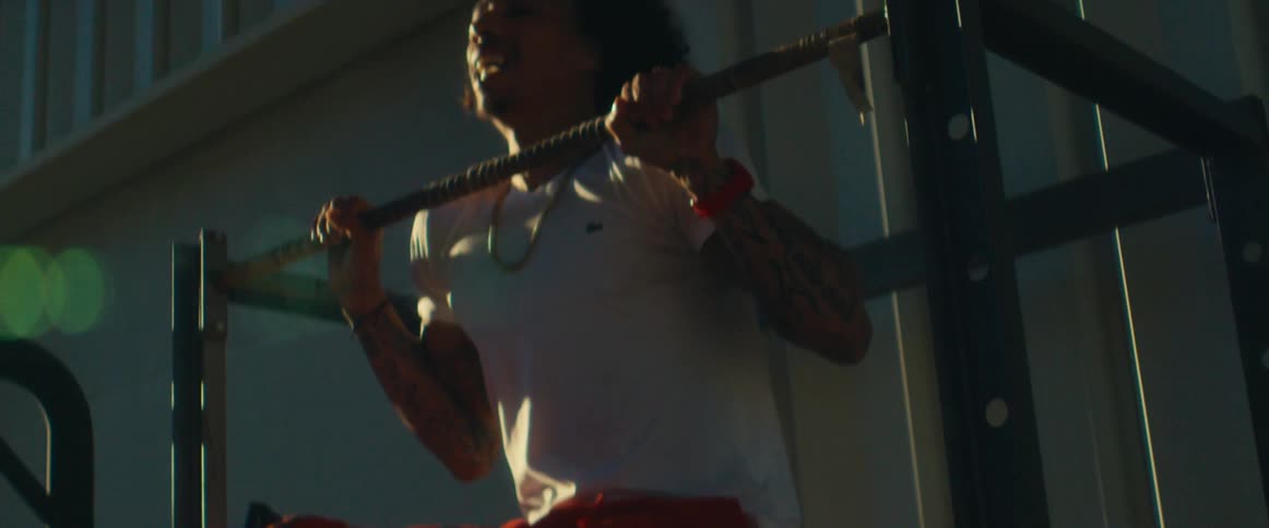 A man is doing pull ups outside