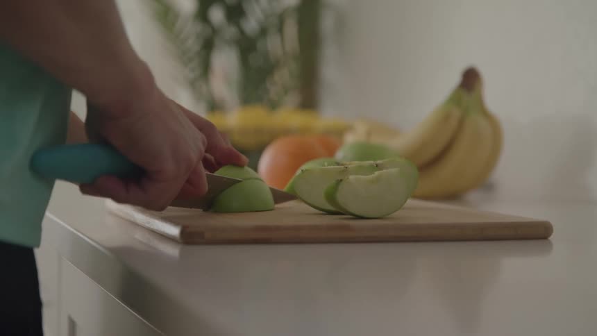 A man is cutting fruit with a knife