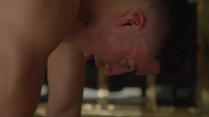 Sweaty man leaning forward during a workout