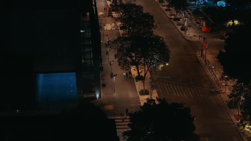 Overhead view of pedestrians and vehicles on an urban city road at night