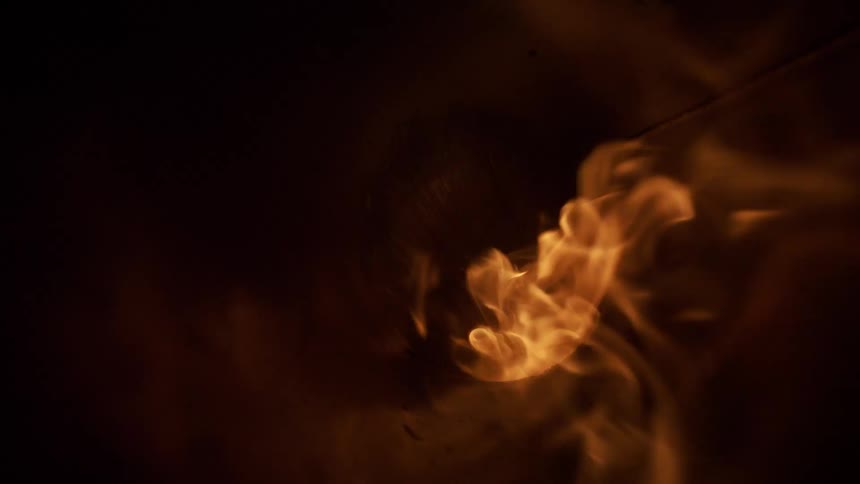 Orange flames in motion against a dark background