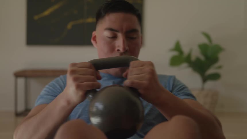 Man exercising with a black kettlebell