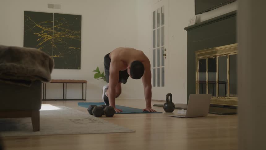 Shirtless man doing abdominal exercises on a mat