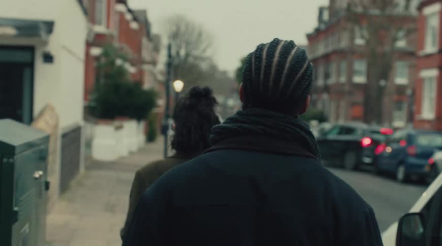 Two people walking down a residential street
