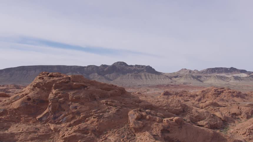 Orange rock formations with mountains in the background