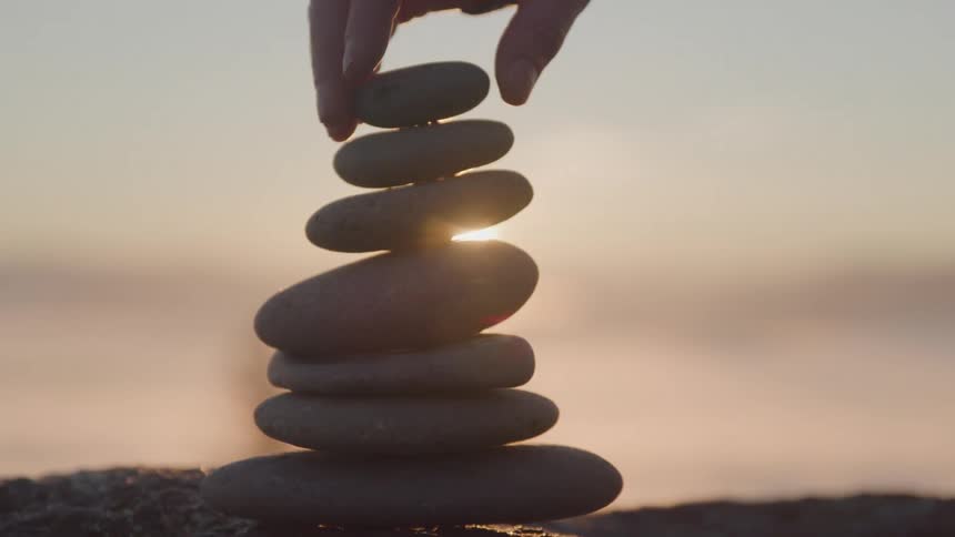 A person stacks thin rocks